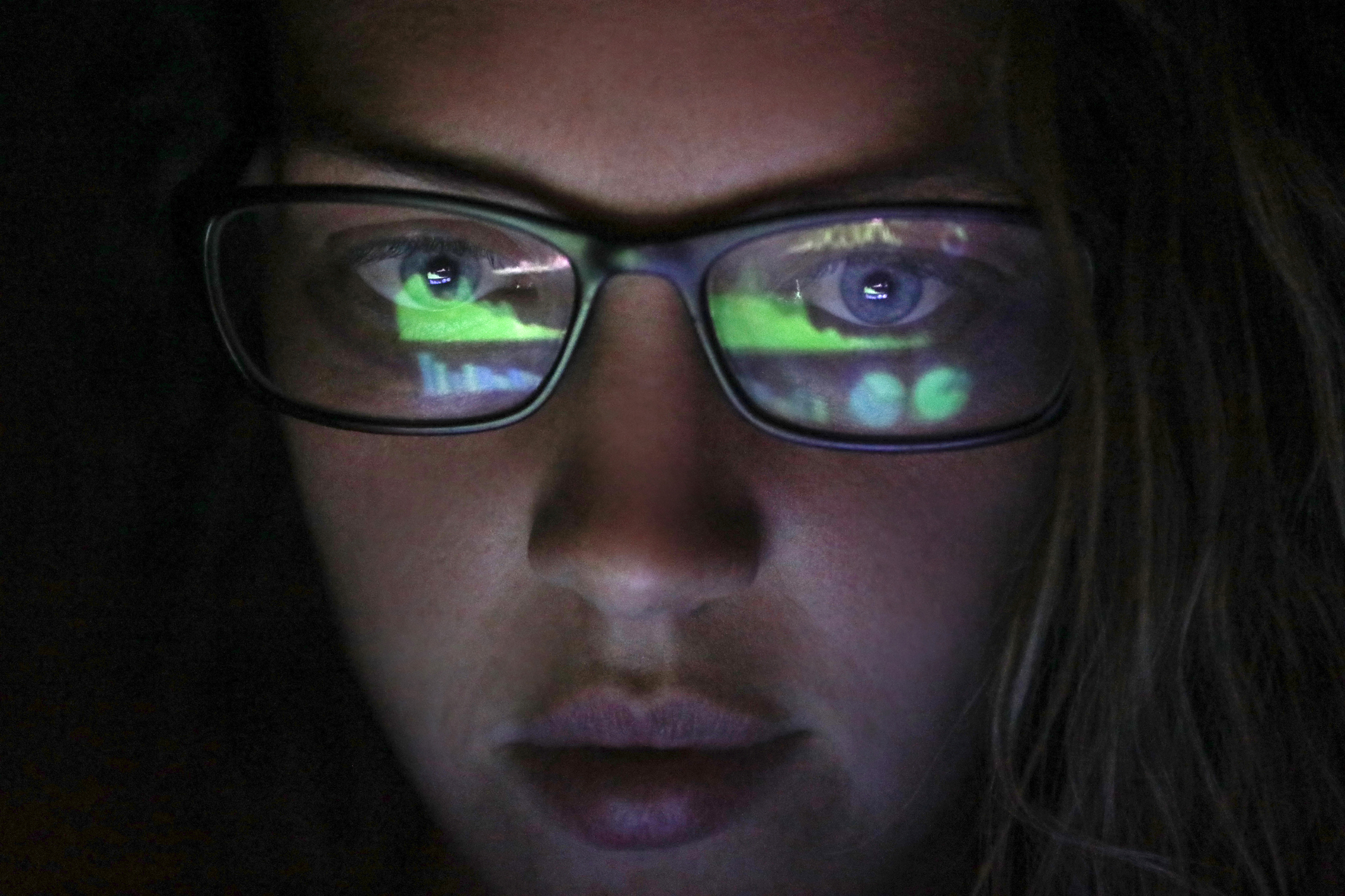 female looking at screen in dark